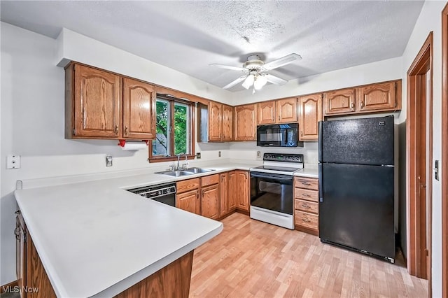 114 Corrin Cir, Cortland, OH 44410 - kitchen featuring black appliances, a peninsula, brown cabinetry, light countertops, and a ceiling fan