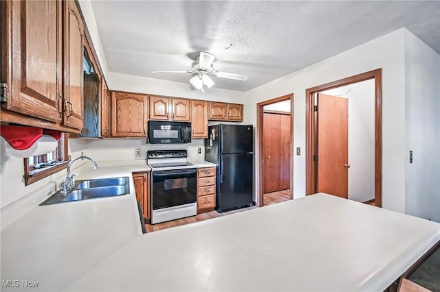114 Corrin Cir, Cortland, OH 44410 - kitchen with black appliances, light countertops, a ceiling fan, a textured ceiling, and a peninsula