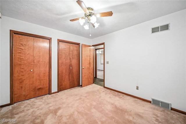 114 Corrin Cir, Cortland, OH 44410 - unfurnished bedroom with two closets, light colored carpet, and ceiling fan