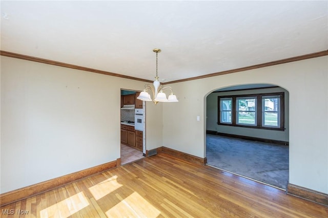 3817 Washington Park Blvd, Newburgh Heights, OH 44105 - unfurnished room with arched walkways, light wood-style floors, a chandelier, and ornamental molding