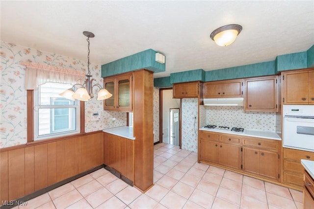 3817 Washington Park Blvd, Newburgh Heights, OH 44105 - kitchen featuring white appliances, wallpapered walls, brown cabinets, a chandelier, and light countertops