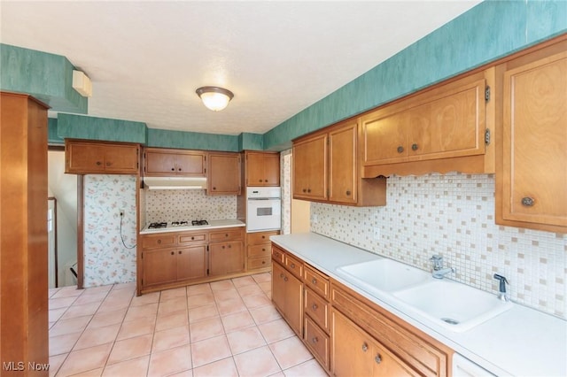 3817 Washington Park Blvd, Newburgh Heights, OH 44105 - kitchen featuring oven, under cabinet range hood, light countertops, and gas stovetop