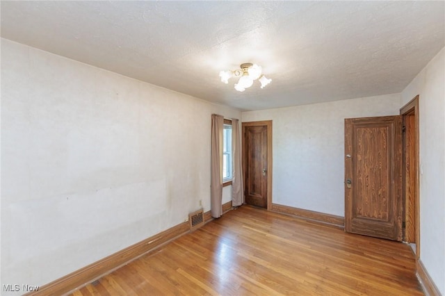 3817 Washington Park Blvd, Newburgh Heights, OH 44105 - empty room with light wood-type flooring and a chandelier