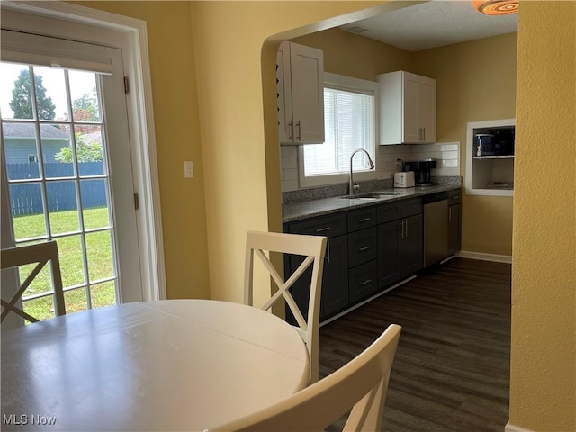 35958 Hiawatha Blvd, Eastlake, OH 44095 - kitchen featuring stainless steel dishwasher, white cabinetry, backsplash, and dark wood-type flooring