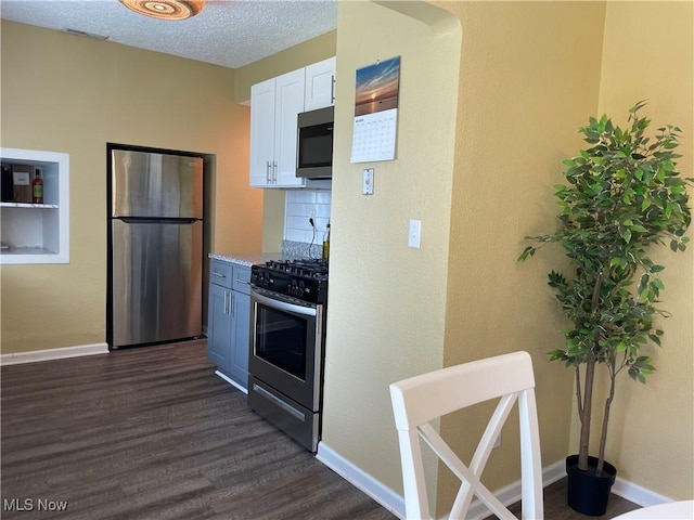 35958 Hiawatha Blvd, Eastlake, OH 44095 - kitchen featuring appliances with stainless steel finishes, white cabinets, dark wood-style floors, light stone counters, and a textured ceiling