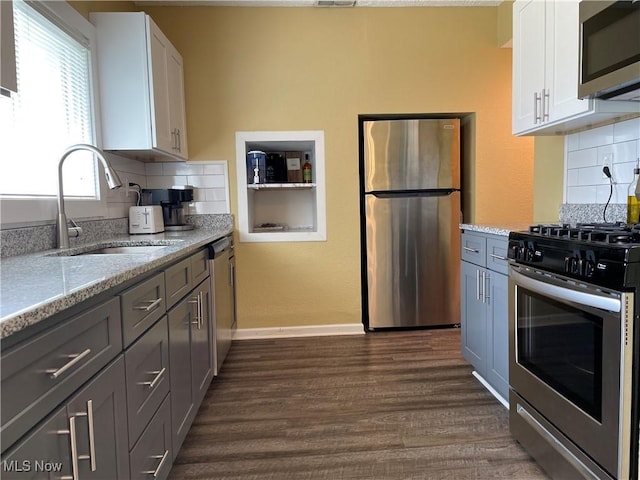 35958 Hiawatha Blvd, Eastlake, OH 44095 - kitchen with stainless steel appliances, dark wood finished floors, white cabinets, tasteful backsplash, and light stone counters