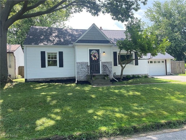 35958 Hiawatha Blvd, Eastlake, OH 44095 - view of front facade featuring an attached garage, driveway, roof with shingles, a chimney, and stone siding