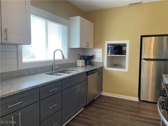 35958 Hiawatha Blvd, Eastlake, OH 44095 - kitchen with appliances with stainless steel finishes, white cabinets, tasteful backsplash, dark wood-style flooring, and light stone counters