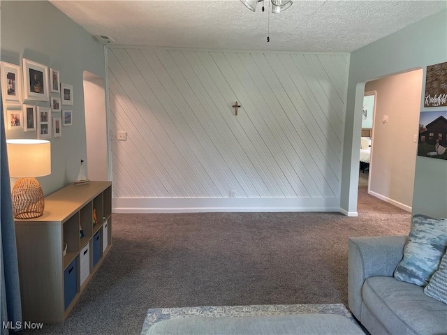 35958 Hiawatha Blvd, Eastlake, OH 44095 - unfurnished living room with carpet, arched walkways, wood walls, and a textured ceiling