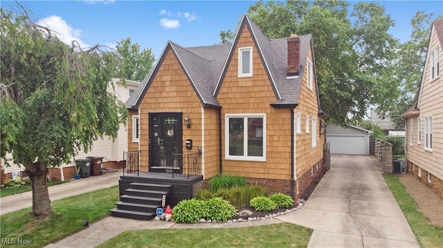 7604 Spring Garden Rd, Parma, OH 44129 - view of front of house featuring an outdoor structure, a shingled roof, a chimney, and a garage