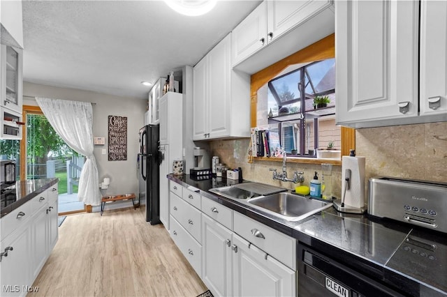 7604 Spring Garden Rd, Parma, OH 44129 - kitchen featuring dark countertops, white cabinetry, light wood finished floors, and black appliances