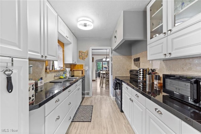 7604 Spring Garden Rd, Parma, OH 44129 - kitchen with black appliances, white cabinetry, dark countertops, light wood finished floors, and backsplash