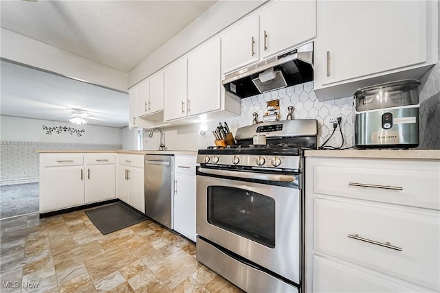 2640 Fleger Dr, Parma, OH 44134 - kitchen featuring appliances with stainless steel finishes, ventilation hood, light countertops, tasteful backsplash, and stone finish floors