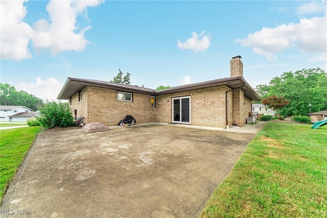2640 Fleger Dr, Parma, OH 44134 - rear view of house with brick siding, a chimney, a yard, and a patio