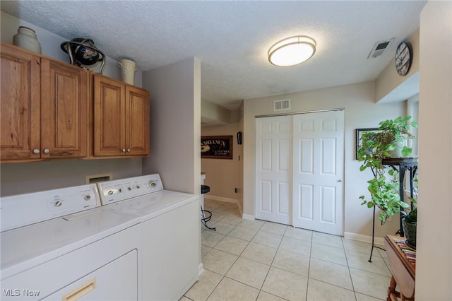 11756 Clarke Rd, Columbia Station, OH 44028 - laundry area featuring washer and dryer, cabinet space, light tile patterned floors, and a textured ceiling