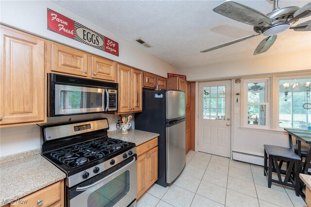 11756 Clarke Rd, Columbia Station, OH 44028 - kitchen with appliances with stainless steel finishes, a baseboard heating unit, ceiling fan, light tile patterned flooring, and a textured ceiling