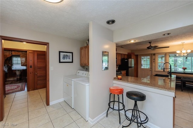 11756 Clarke Rd, Columbia Station, OH 44028 - laundry area featuring independent washer and dryer, a textured ceiling, light tile patterned flooring, a chandelier, and ceiling fan