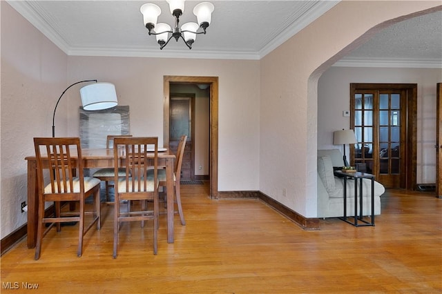 4019 Euclid Blvd, Youngstown, OH 44512 - dining space with arched walkways, a chandelier, light wood-style flooring, and crown molding