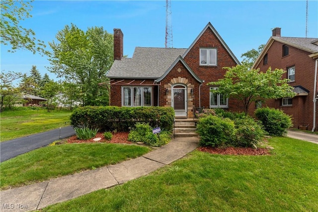 4019 Euclid Blvd, Youngstown, OH 44512 - tudor home featuring a front lawn, brick siding, and a chimney