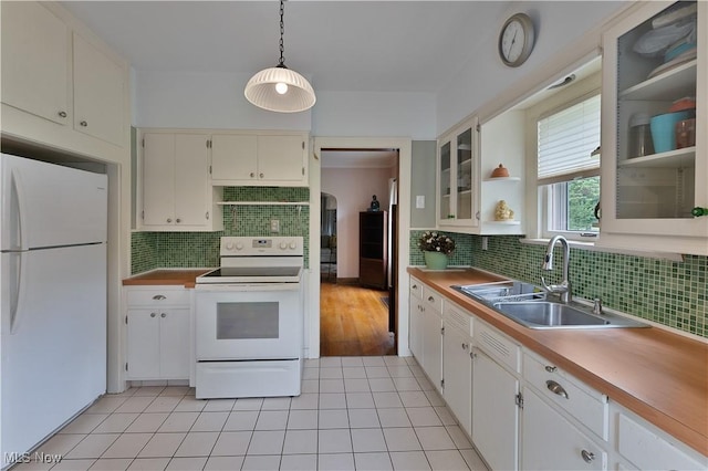 4019 Euclid Blvd, Youngstown, OH 44512 - kitchen featuring white appliances, tasteful backsplash, glass insert cabinets, light tile patterned floors, and exhaust hood