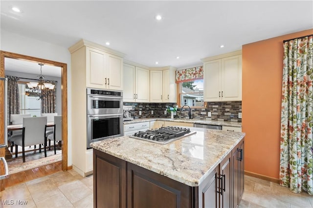 3100 Ravineview Cir, Stow, OH 44224 - kitchen featuring appliances with stainless steel finishes, a chandelier, cream cabinets, backsplash, and recessed lighting