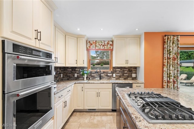 3100 Ravineview Cir, Stow, OH 44224 - kitchen featuring appliances with stainless steel finishes, decorative backsplash, light stone counters, cream cabinetry, and recessed lighting