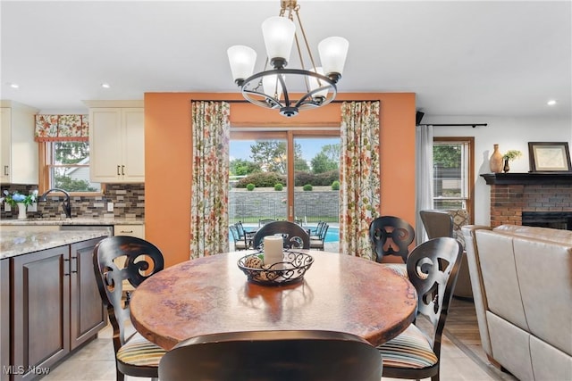 3100 Ravineview Cir, Stow, OH 44224 - dining space with plenty of natural light, a chandelier, recessed lighting, and a brick fireplace