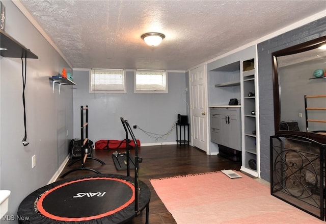 3921 Grosvenor Rd, South Euclid, OH 44118 - exercise room featuring a textured ceiling, built in shelves, and dark wood-style floors