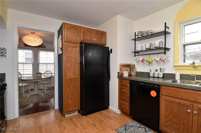 3921 Grosvenor Rd, South Euclid, OH 44118 - kitchen featuring black appliances, light wood-type flooring, dark countertops, and brown cabinetry