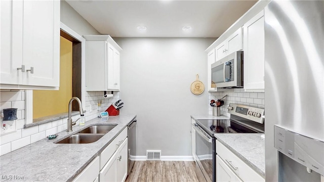 87 Holcomb Ave, Mogadore, OH 44260 - kitchen featuring stainless steel appliances, tasteful backsplash, and white cabinetry