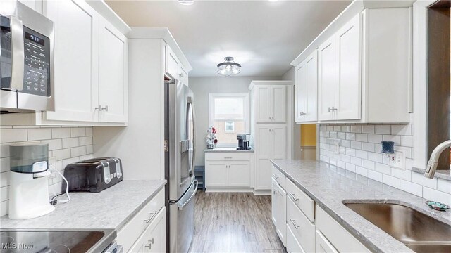 87 Holcomb Ave, Mogadore, OH 44260 - kitchen featuring stainless steel appliances, white cabinets, and light wood-style floors