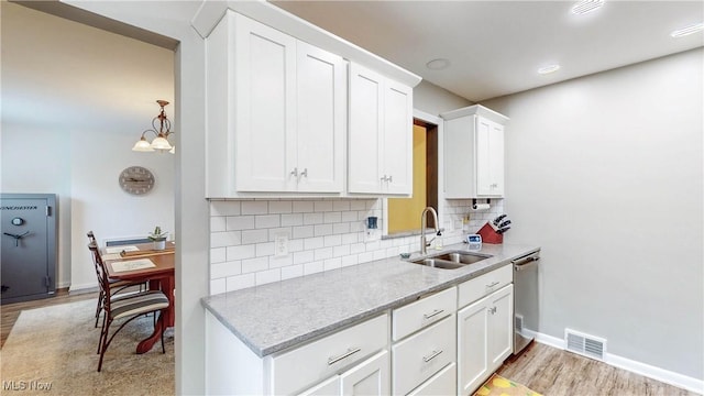 87 Holcomb Ave, Mogadore, OH 44260 - kitchen featuring light wood finished floors, tasteful backsplash, white cabinets, and light stone countertops