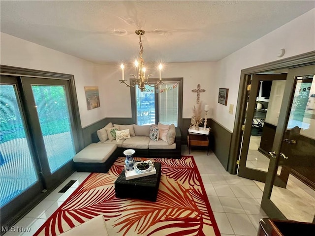 23547 Quail Holw, Westlake, OH 44145 - living room with a chandelier, a wainscoted wall, and light tile patterned floors