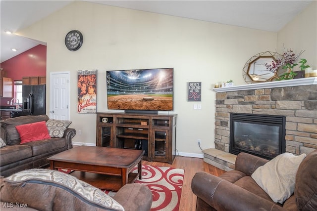 4504 Ledge Ct, Kent, OH 44240 - living room with vaulted ceiling, wood finished floors, and a stone fireplace