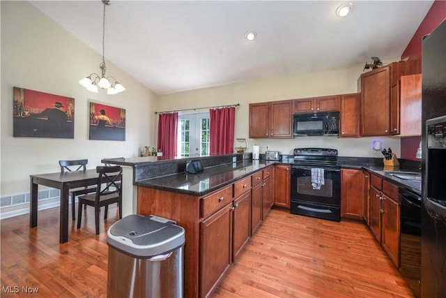 4504 Ledge Ct, Kent, OH 44240 - kitchen with black appliances, a peninsula, light wood-type flooring, vaulted ceiling, and a chandelier