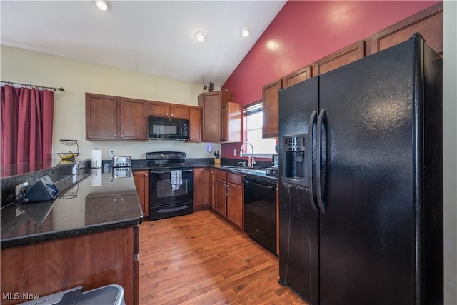 4504 Ledge Ct, Kent, OH 44240 - kitchen featuring black appliances, light wood-style floors, high vaulted ceiling, recessed lighting, and dark stone counters