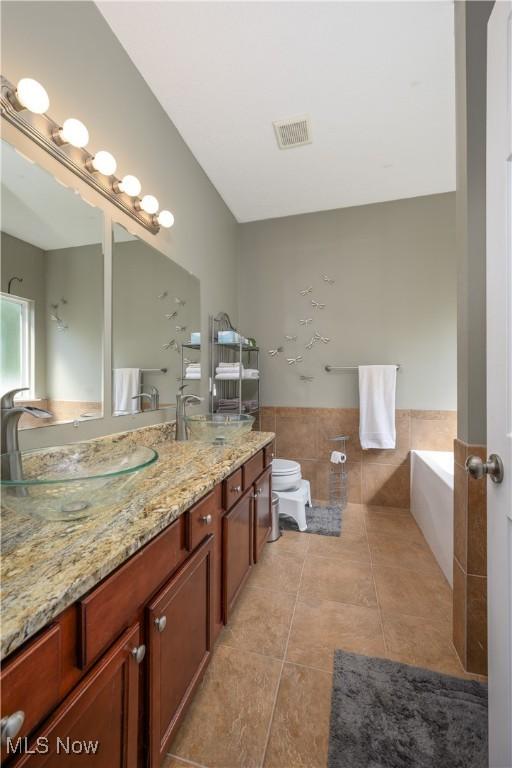 4504 Ledge Ct, Kent, OH 44240 - bathroom featuring a garden tub, vanity, and tile patterned flooring
