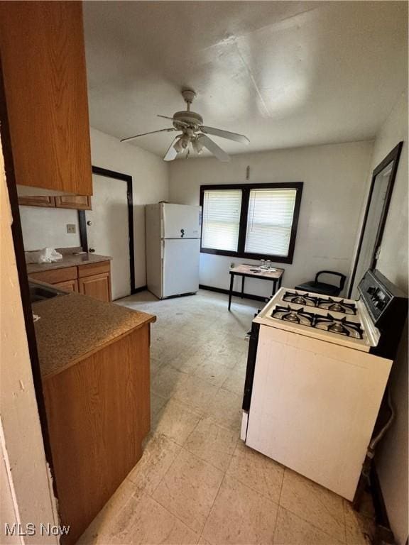 699 E 156th St, Cleveland, OH 44110 - kitchen featuring white appliances, ceiling fan, and brown cabinetry