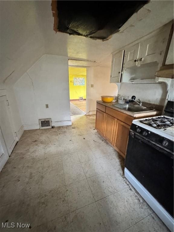 699 E 156th St, Cleveland, OH 44110 - kitchen featuring range with gas stovetop, light flooring, and brown cabinetry