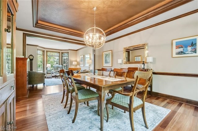 32305 Monaco Pl, Avon Lake, OH 44012 - dining room with a raised ceiling, ornamental molding, a chandelier, and wood finished floors