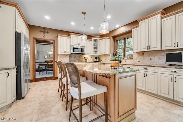 32305 Monaco Pl, Avon Lake, OH 44012 - kitchen with appliances with stainless steel finishes, a kitchen breakfast bar, tasteful backsplash, a kitchen island, and decorative light fixtures