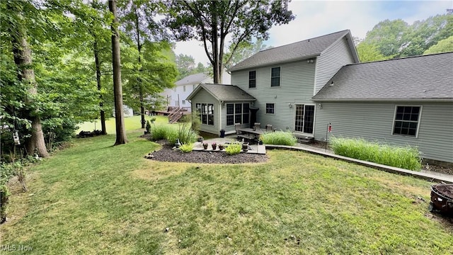 6190 3rd Ave, Kent, OH 44240 - back of property featuring a yard, a patio area, a sunroom, roof with shingles, and an outdoor fire pit