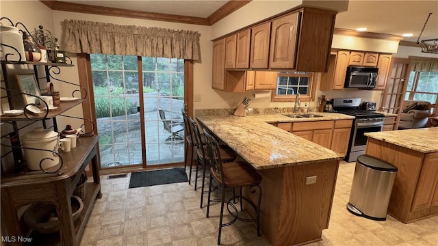 6190 3rd Ave, Kent, OH 44240 - kitchen with stainless steel gas range, crown molding, a breakfast bar area, light stone counters, and a peninsula