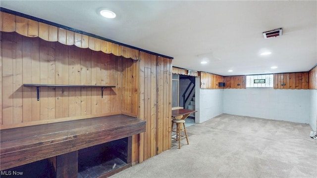 1672 Battery B St, Akron, OH 44305 - below grade area with stairway, light carpet, wooden walls, and concrete block wall