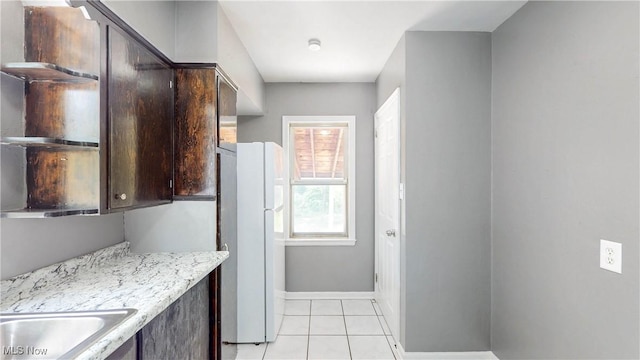 1672 Battery B St, Akron, OH 44305 - kitchen featuring freestanding refrigerator, dark brown cabinetry, and light tile patterned flooring