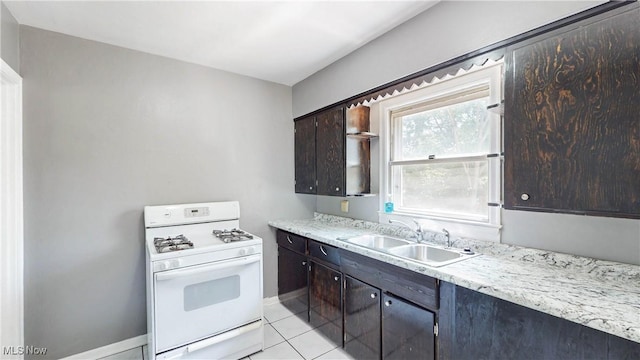 1672 Battery B St, Akron, OH 44305 - kitchen with white range with gas stovetop, dark brown cabinets, and light tile patterned floors