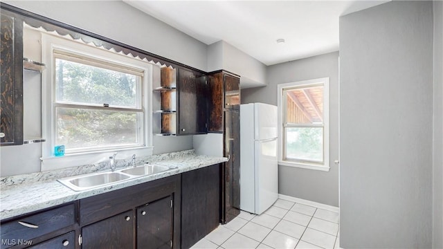 1672 Battery B St, Akron, OH 44305 - kitchen with freestanding refrigerator, light tile patterned floors, and dark brown cabinetry