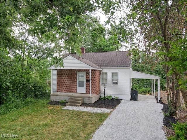 1672 Battery B St, Akron, OH 44305 - bungalow featuring a chimney, an attached carport, a front lawn, driveway, and brick siding