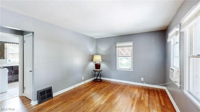 1672 Battery B St, Akron, OH 44305 - empty room featuring light wood-style floors, healthy amount of natural light, and cooling unit