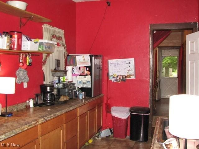 124 Hickory St, Andover, OH 44003 - kitchen with tile patterned floors and brown cabinetry